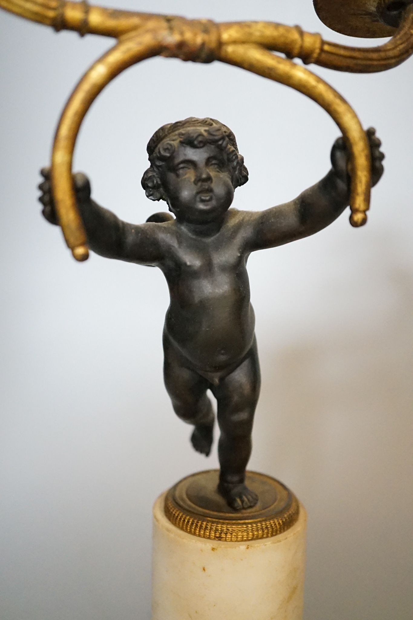 A pair of 19th century bronze and ormolu cherub candelabra, on alabaster plinths, 33cm